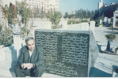 الصائغ أمام قبر الجواهري في مقبرة الغرباء. دمشق. كانون الثاني 2002 مصدر الصورة: adnanalsayegh.com