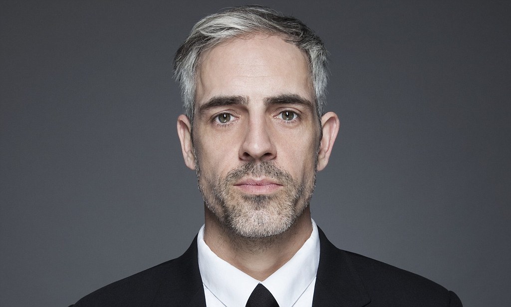 Man with graying hair in black suit