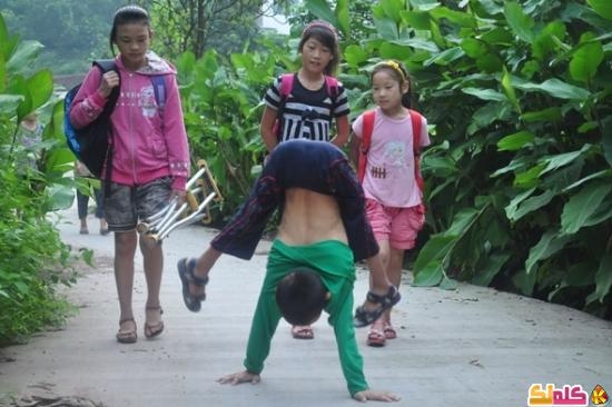 طفل صيني يذهب إلى المدرسة سيراً على الكفين بالصور