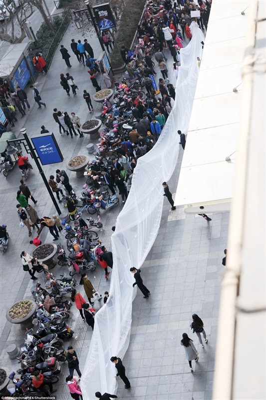 بالفيديو والصور.. «موديل» تسير بفستان طوله 100 متر في شوارع الصين