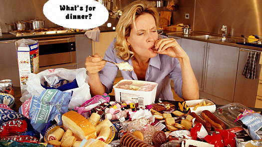 Woman at table overloaded with food