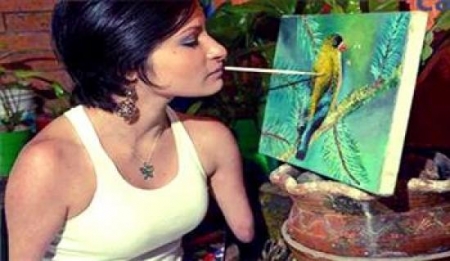 كولومبية بلا يدين تحترف الرسم بالفم وتنتج لوحات رائعة