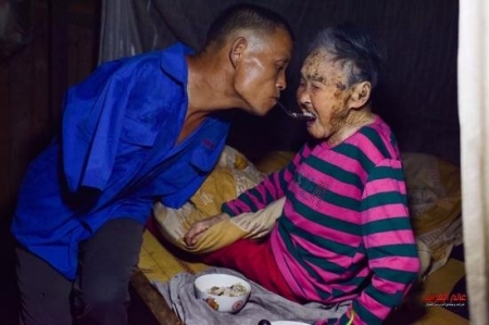شاب صيني بدون ذراعين يطعم والدته المشلولة بواسطة أسنانه 