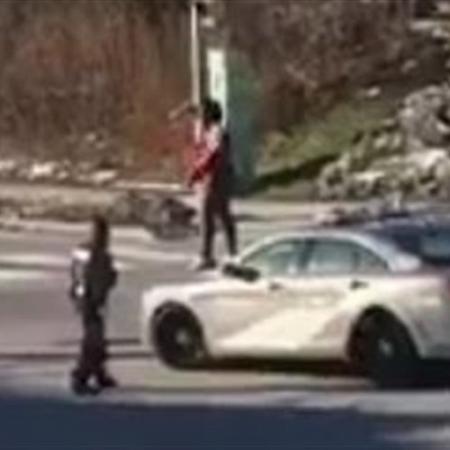 بالفيديو امرأة تقفز أعلى سيارة شرطة وتحطمها