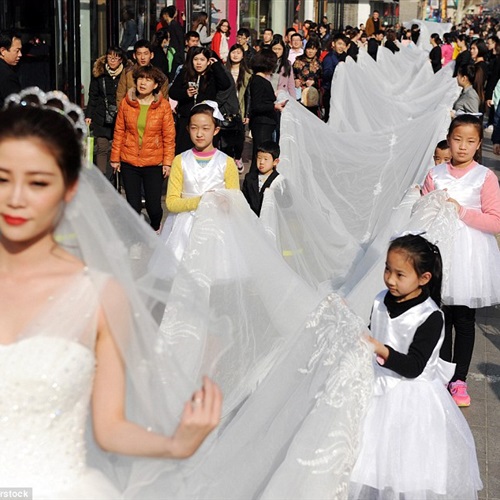بالفيديو والصور موديل تسير بفستان طوله 100 متر في شوارع الصين